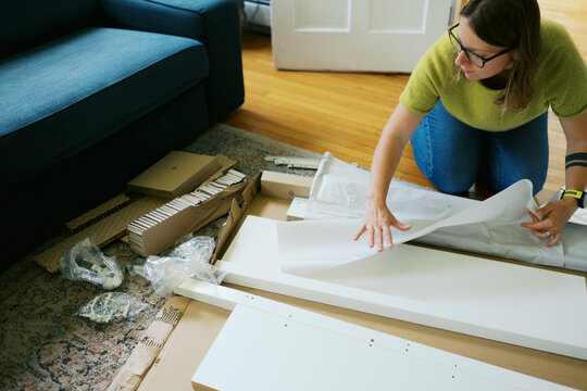 woman in her living room at home assembling furniture