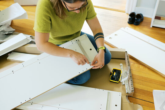 woman in her living room at home assembling furniture