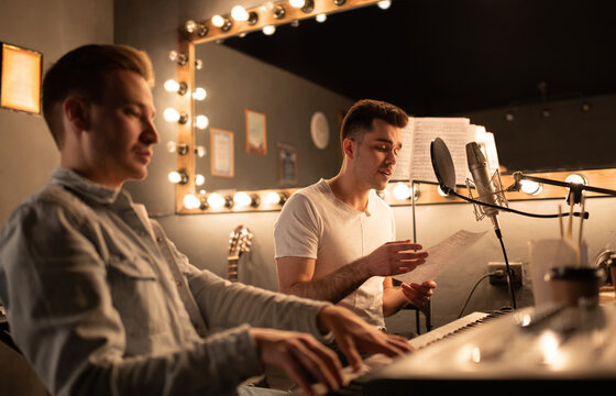 Men playing and singing song together in sound studio