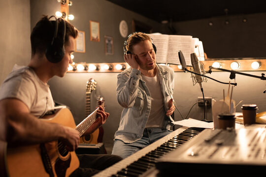 Men creating song in modern sound studio