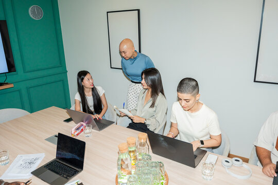 Meeting in a Conference Room With Team Members Discussing Ideas