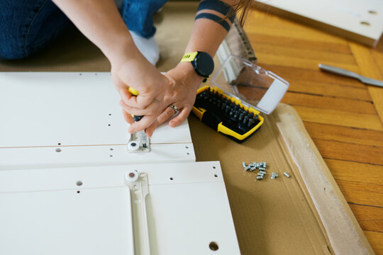 woman in her living room at home assembling furniture
