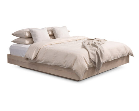 Light wood platform bed with stacked pillows and isolated on png transparent background