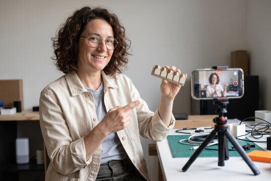 Woman entrepreneur filming an online workshop for social media using a phone on tripod