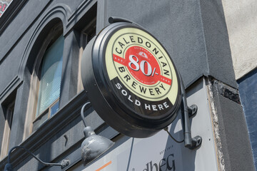 Obraz premium wall-mounted round beer sign for Caledonian 80 Shilling ale Brewery on the exterior of The Caledonian, a pub, located at 856 College St, Toronto