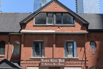 Obraz premium Town Crier Pub sign on the exterior of a heritage building at 115 John St, Toronto