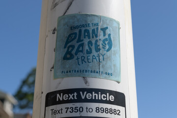 Obraz premium close-up of a “Endorse the Plant Based Treaty” sticker with campaign slogan on a bus stop pole (Spadina Rd at Dupont St — Dupont Station, 127 Davenport bus), Toronto