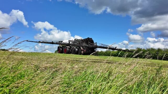 Modern slurry tanker with trailing hose applicator on a meadow in action. The high capacity slurry tanker demonstrates modern farming technology for fertilization and soil management on open grassland