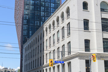 Obraz premium Eclipse Whitewear Building, a former underwear factory, contrasted with PJ Condos at 283 Adelaide Street West / 99 John Street, designed by Hariri Pontarini Architects, Toronto