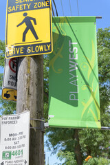 Obraz premium pole-mounted, projecting Play West banner on College St, Toronto (with traffic signs)