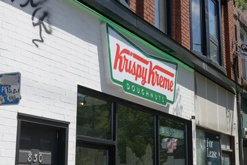 Obraz premium exterior building facade and sign of Krispy Kreme Café, a donut shop chain, located here at 830 College St, Toronto