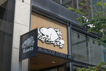 Obraz premium wall-mounted projecting and shop front signs outside Roots, a clothing store chain, located here at 80 Bloor St W, inside Fairview Building, Toronto