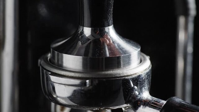 Espresso portafilter coffee machine metal chrome closeup brewing cafe barista shiny handle fresh ground tamped coffee dark background hot drink preparation detail