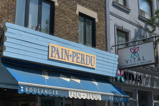 exterior building facade and sign of Pain Perdu, a cafe and pastry shop, located at 736 St Clair Av W, Toronto