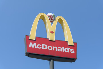 Fototapeta premium iconic Golden Arches and sign of McDonald's Canada fast food restaurant located at 710 St Clair Av W, Toronto - with Trionda soccer ball by Adidas cf FIFA World Cup 2026 