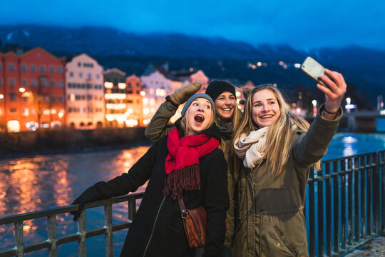 Happy young women taking selfie in Innsbruck at night