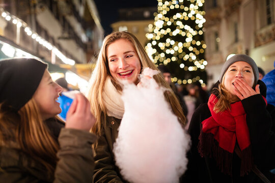 Friends enjoying cotton candy at Christmas market