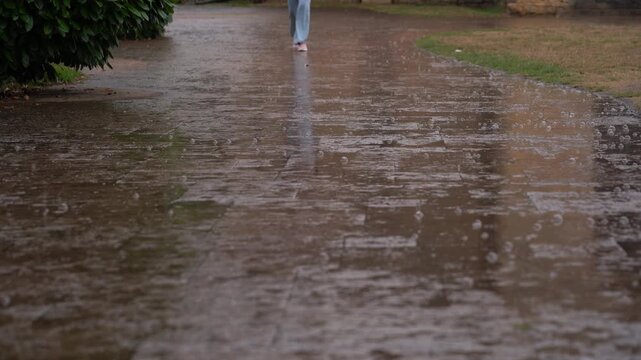 Detalle de un d&iacute;a de lluvia en Oviedo, con el suelo empedrado mojado por la lluvia y los pies de varias personas caminando sobre las calles del casco hist&oacute;rico. 