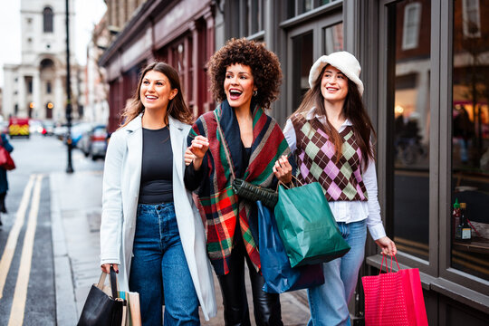 Happy diverse women friends shopping on London street