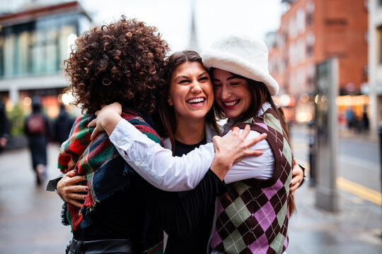 Happy young women embracing on city street