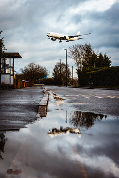 Airplane approaching for landing with street reflection