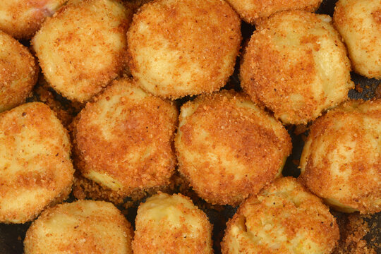 A macro shot of traditional sweet potato dumplings coated in golden fried breadcrumbs known as knedle in central and eastern Europe.