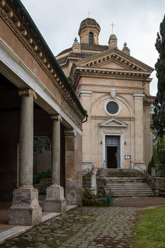 The facade of Santa Maria Scala Coeli church framed by the portico columns at Tre Fontane Abbey in Rome, Italy