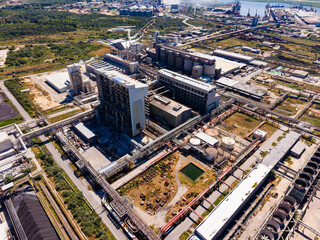 Fototapeta premium Large industrial complex located near a river with multiple storage tanks and pipelines visible during daylight hours