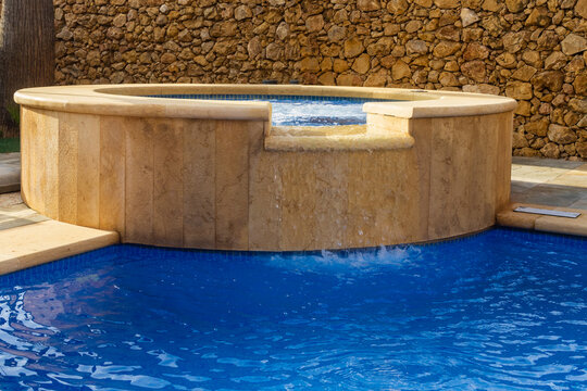 Backyard Luxury Spa Pool With Stone Hot Tub Jacuzzi Overflow Waterfall and Blue Swimming Pool
