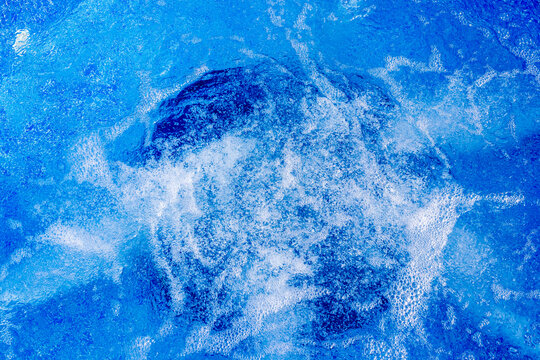 Bubbling Blue Pool Water Over Mosaic Tiles With Whirlpool Jets Creating Foam and Motion