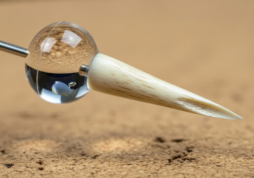 Clear water drop on a small white sewing pin