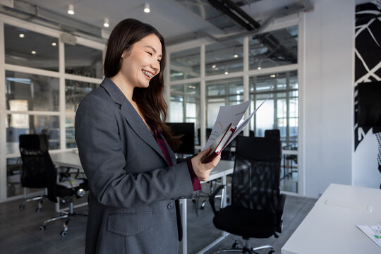 Long-haired woman in the office analyzing documents for new project