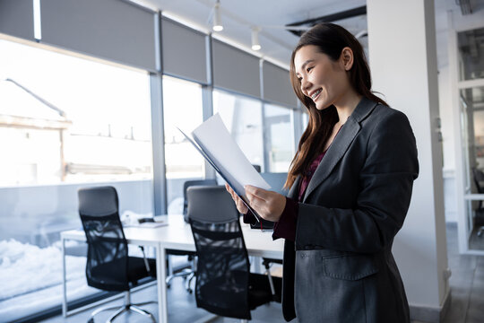 Long-haired woman in the office analyzing documents for new project