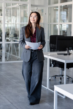 Long-haired woman in the office analyzing documents for new project