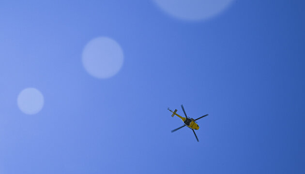 Fire-fighting helicopter aircraft in the blue sky.