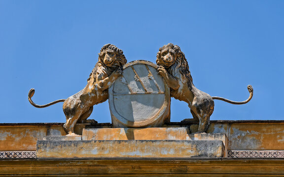 Detailed view of a traditional stone coat of arms with lions on a historic roofline balustrade in Palermo, Italy. Elegant geometric frieze patterns and classic Sicilian heritage.