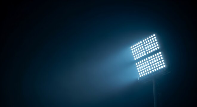 Bright stadium floodlights shining in the dark night