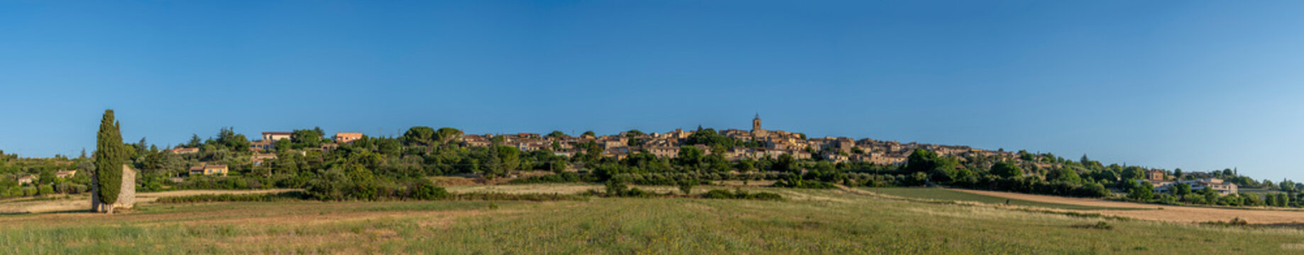 Puimoisson, France - 07 04 2026: Panoramic view of Puimoisson hilltop village under a blue sunny sky