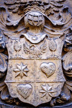 Historical carving of a sword and olive branch on stone wall in a public place during midday