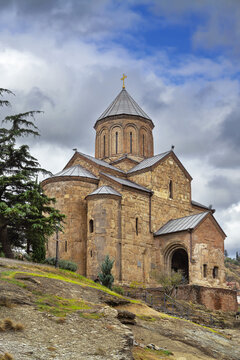 Virgin Mary Metekhi Church in Tbilisi, Georgia, medieval cross-in-square architecture style. Overcast weather with cloudy sky