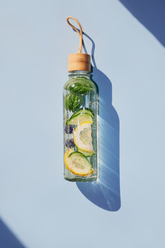 Reusable glass bottle filled with refreshing infused water, promoting healthy hydration and wellness