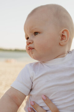 Close-up portrait of a curious baby with chubby cheeks looking away outdoors