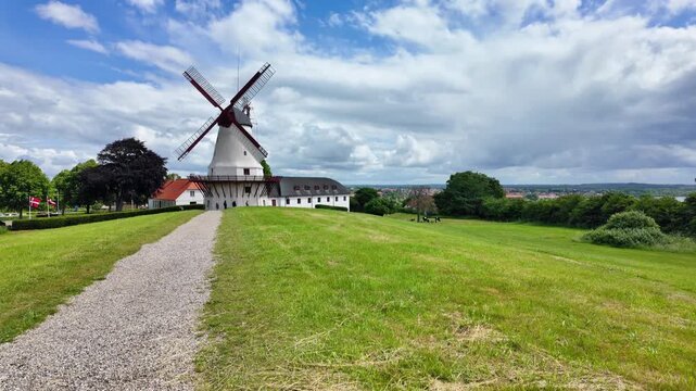 Historic Dybbol Mill on the Duppel Redoubts near Sonderborg, Denmark beneath a blue sky with impressive clouds and open countryside.