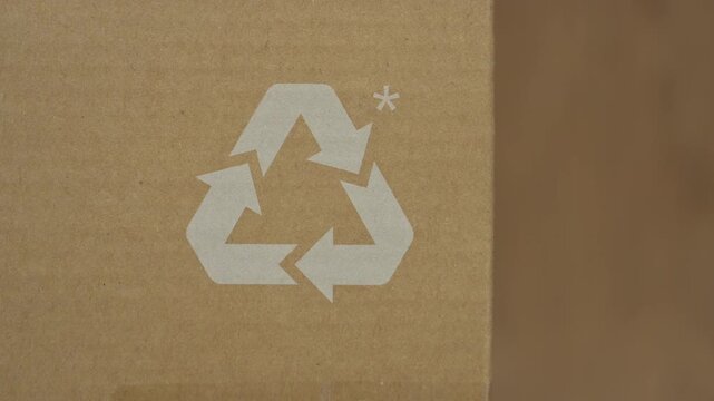 Recycling sign printed brown cardboard packaging background White symbol emphasizing sustainable materials eco friendly shipping solutions commercial green marketing campaigns macro detail paper box w