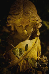 Fototapeta premium Ancient cemetery angel statue illuminated by warm golden light, symbolizing remembrance, hope, peace and eternal love.