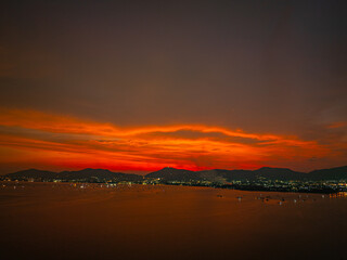 Fototapeta premium Scenic sunset seascape from above featuring Chalong Bay, Phuket Island, and the colorful evening sky, creating a peaceful tropical travel destination.