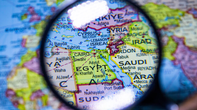 Magnifying glass examining map of Egypt and Middle East region.