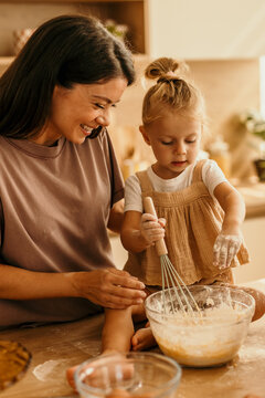 Mother and daughter baking together in kitchen