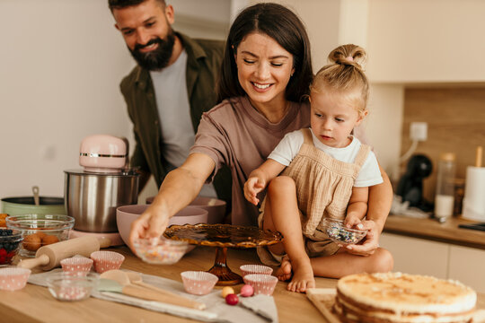 Family baking cake together in kitchen at home