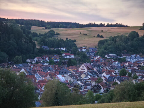 germany, enchanting sunset above elzach village rooftops surrounded by the magnificent schwarzwald landscape beneath vibrant summer blue sky and warm evening light